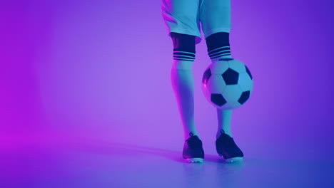 Schwarzer-Mann,-Ein-Spieler-Jongliert-Mit-Fußball-In-Einem-Dunklen-Studio-Mit-Neonlichtern-Auf-Dem-Boden-Und-Roten-Und-Blauen-Lichteffekten-In-Zeitlupe.-Afrikanischer-Fußballprofi